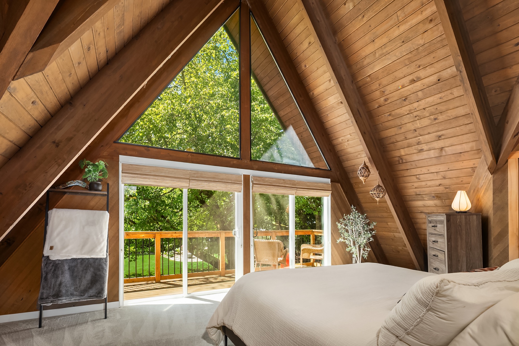 Primary bedroom with triangular A-frame window over the deck